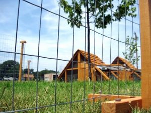 Closeup of bottom of fence post with coops behind